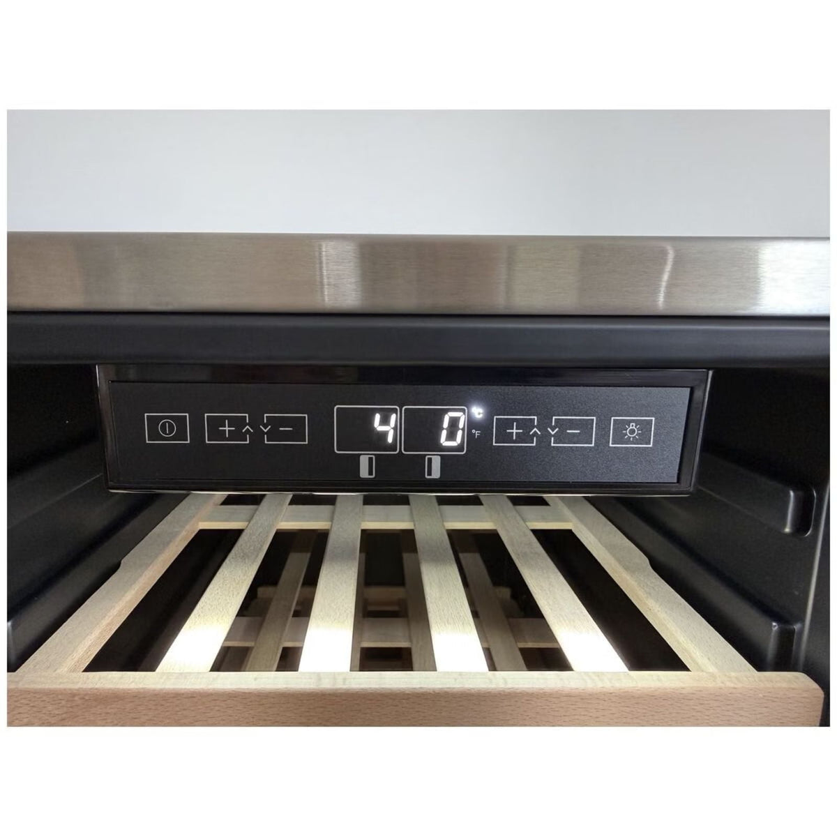 Close-up of a wine cooler or refrigerator interior showing the control panel with a digital display and wooden wine rack shelves.