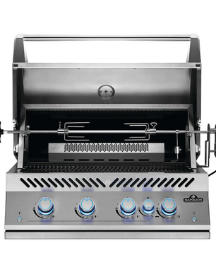 A stainless steel outdoor gas grill with a rotisserie spit assembly, shown open against a solid white background. The front features five blue-tinted control knobs on a brushed metal panel with the 'STANLEY ROE' brand logo in the bottom right corner.