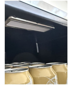 A close-up of a dark interior ceiling or compartment with a long rectangular light fixture and several beige fabric or paper bags hanging below.