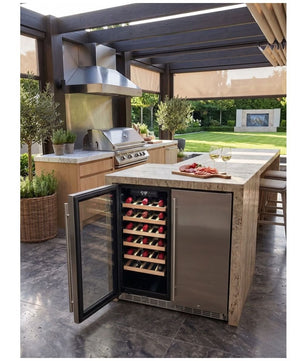A stainless steel outdoor island wine refrigerator with a glass door, shown open with wine bottles inside, set in a modern patio kitchen environment.