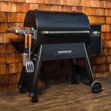 Black barbecue grill with wooden wall background