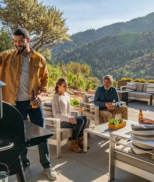 Group of people enjoying a barbecue outdoors with mountains in the background