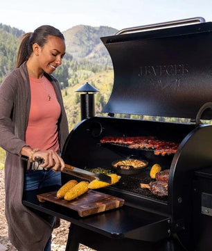Woman grilling outdoors with a mountainous background