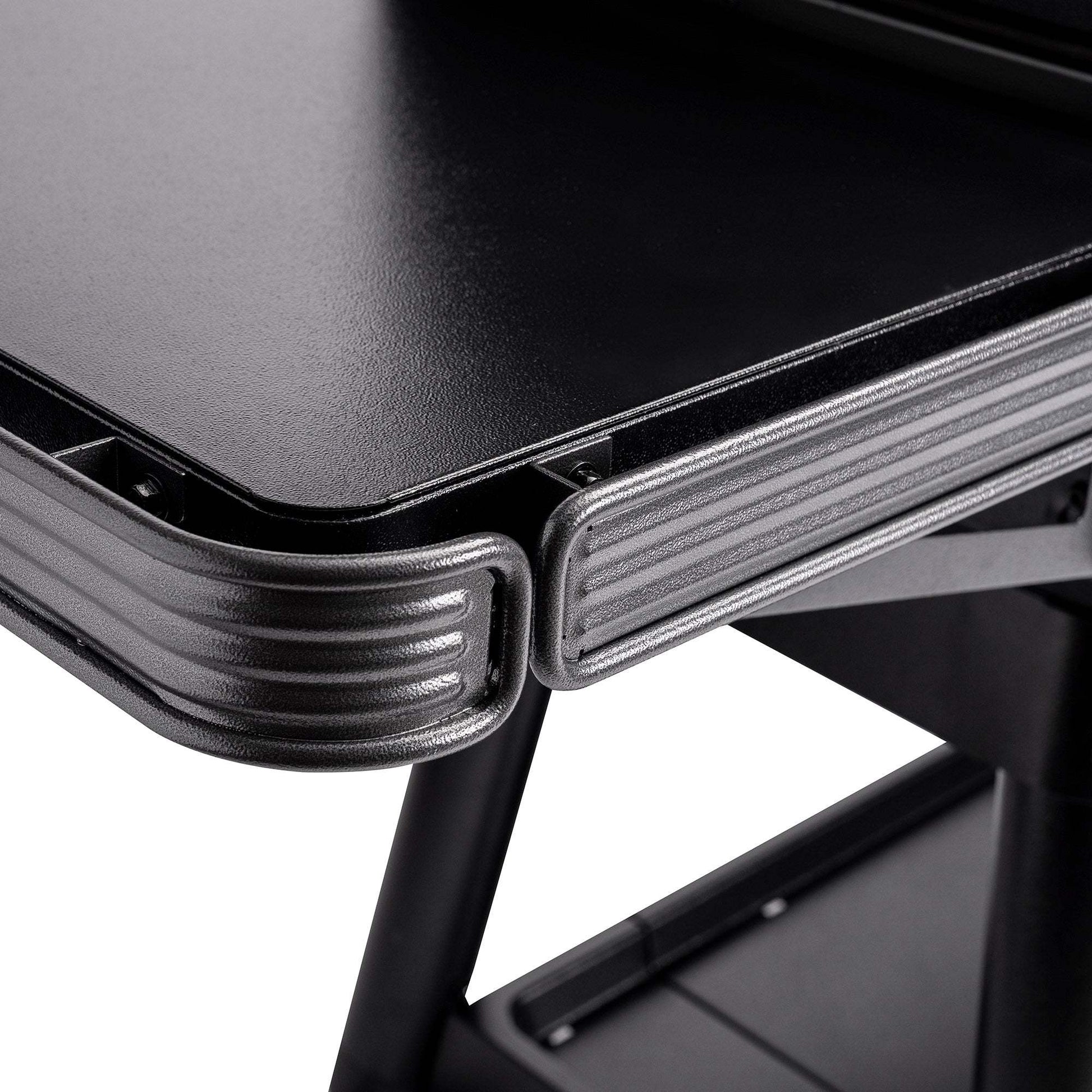 Close-up of a black metal desk corner with a white background