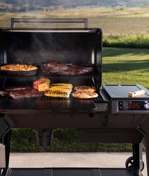 Portable grill with food cooking outdoors on a grassy area