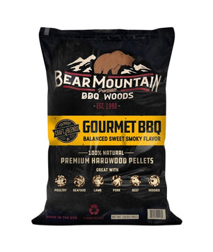 A black bag of Bear Mountain Gourmet BBQ hardwood pellets on a plain white background. The packaging features a brown bear logo, white and yellow text, and illustrations of different meats at the bottom.
