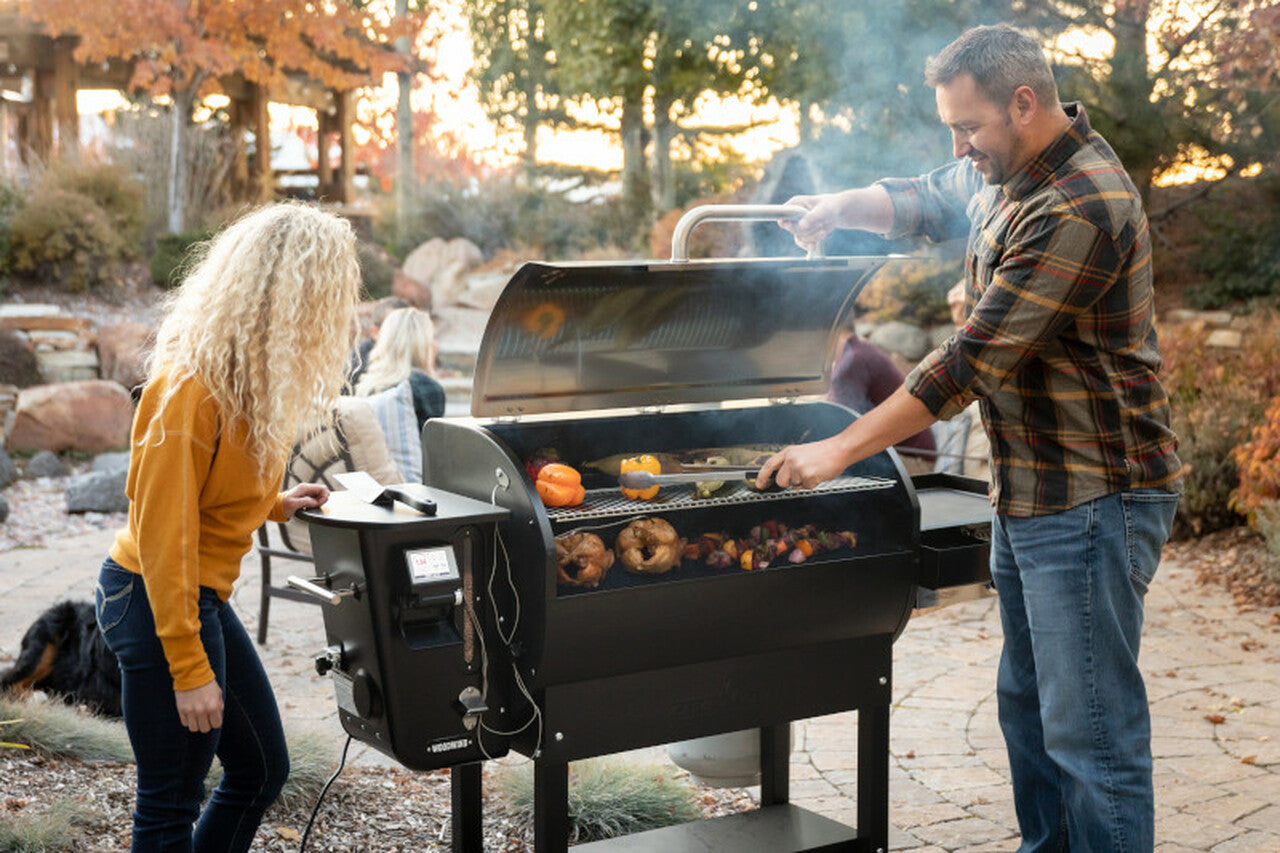 Man and woman grilling on a GMG smoker