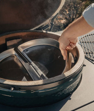 Person interacting with a green barbecue grill on a boat