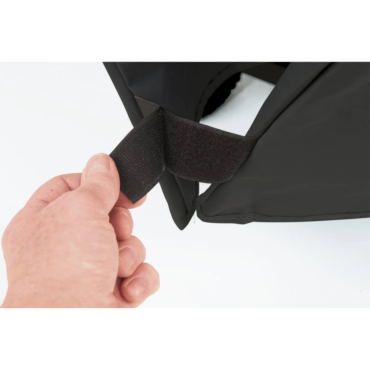 Hand adjusting a black strap on a car seat cover against a white background