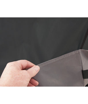 Hand holding a gray fabric panel against a black background