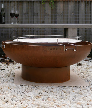 Outdoor fire pit with a bottle and glasses on a wooden deck