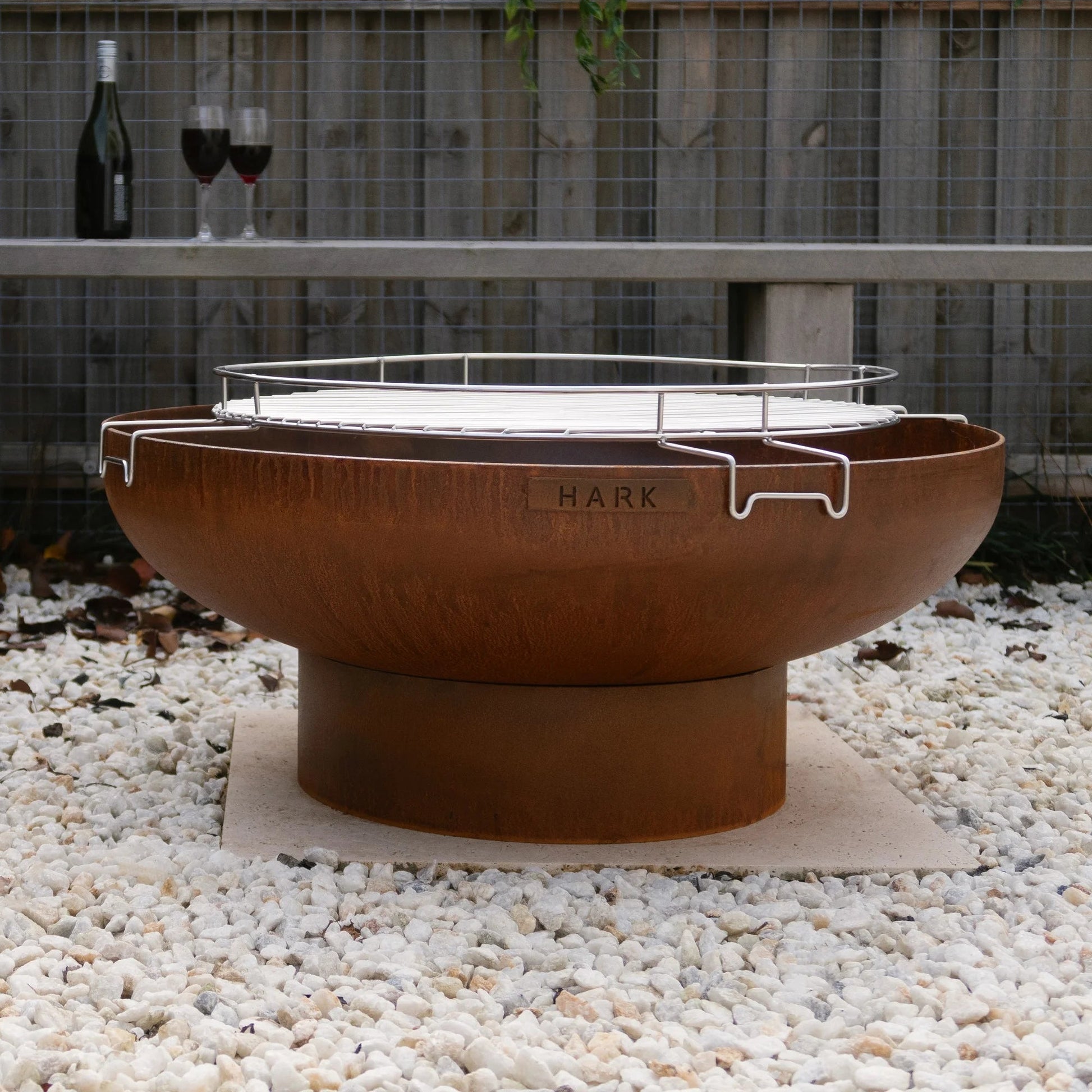 Outdoor fire pit with a bottle and glasses on a wooden deck