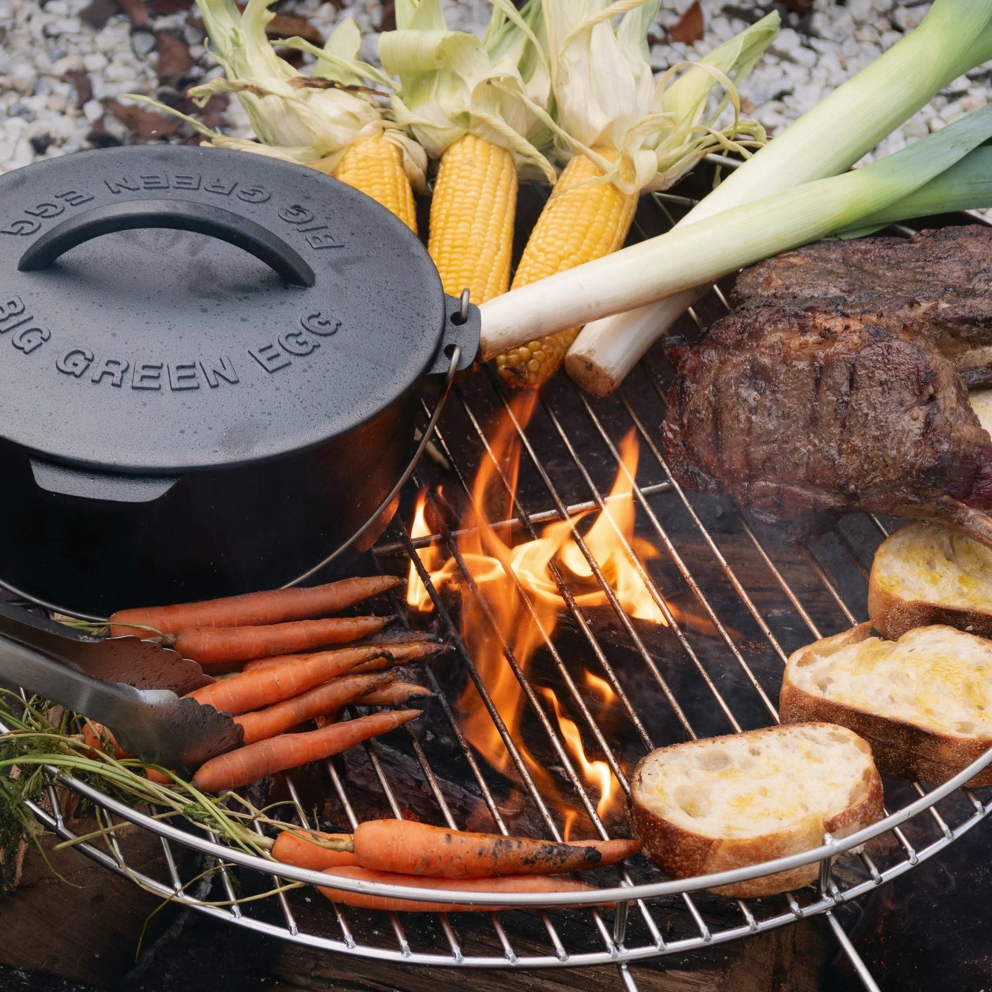 Grill with vegetables and a pot on a stone surface