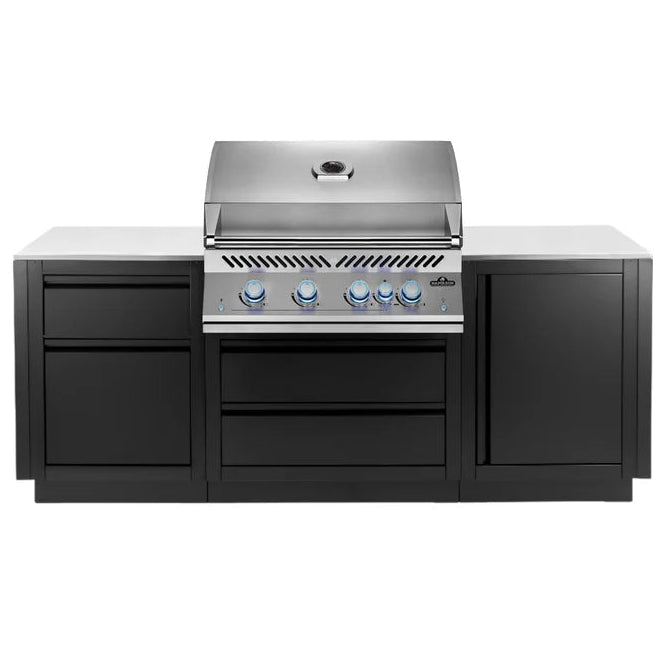 A professional outdoor kitchen island set featuring a stainless steel gas grill with four blue control knobs, integrated into a black cabinet base with a light gray stone countertop, shown against a solid white background.