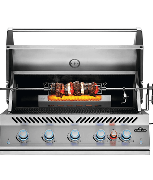 A stainless steel outdoor rotisserie grill with five blue and red control knobs on the front, shown open with a rotisserie spit holding grilled meat and peppers over a flame. The brand name 'Starfire' is visible on the lower right front panel.