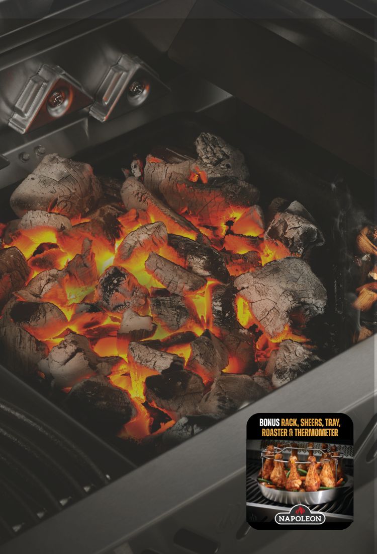 Grill with glowing coals and a Napoleon grill accessory pack on a black background