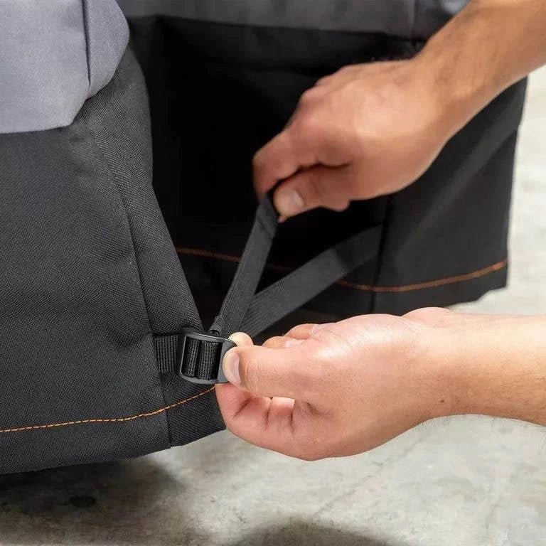 Person adjusting a black strap on a gray bag.
