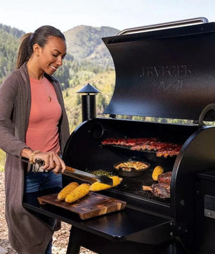 Woman grilling outdoors with a mountainous background