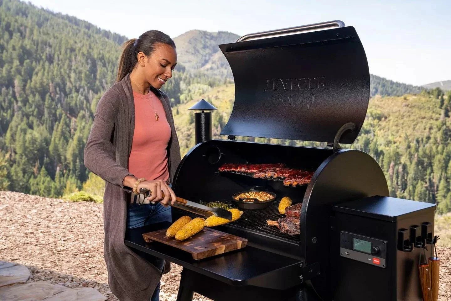 Woman grilling outdoors with a mountainous background