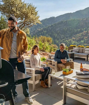 Group of people enjoying a barbecue outdoors with mountains in the background