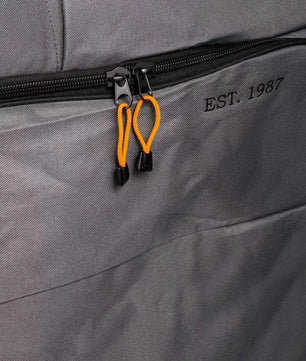 Close-up of a gray bag with a zipper and 'EST. 1987' branding.