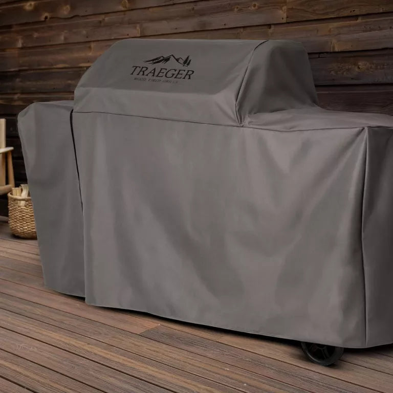 Traeger grill cover on a wooden deck with a wooden wall background