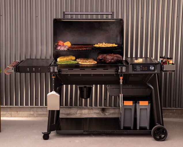 Multifunctional grill with cooking area and side burners on a gray background